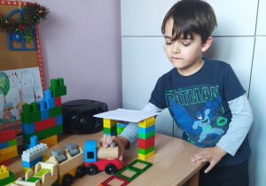 Chłopiec buduje przejazd dla pociągu